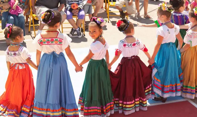 Hispanic girls dancing in costumes