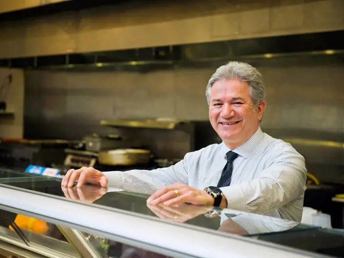 Hispanic businessman smiling in kitchen