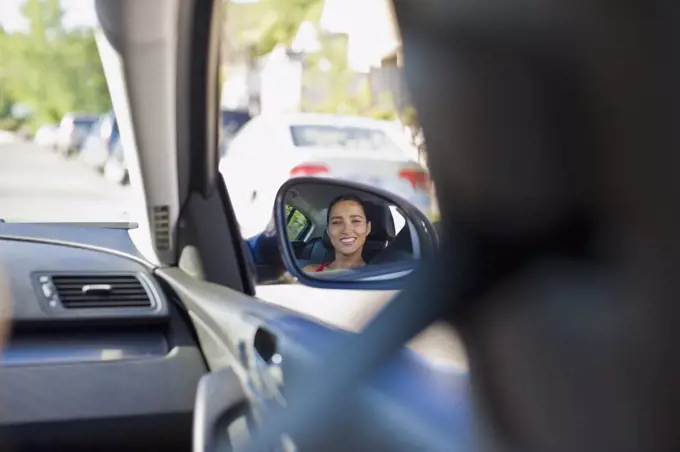 Image of Hispanic woman in cars side mirror
