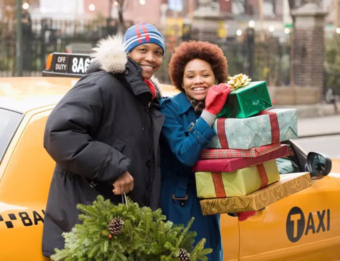 African couple with Christmas presents and wreath