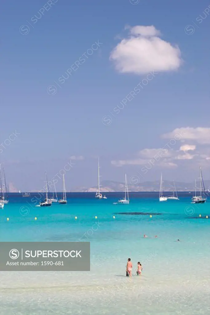 Spain, Formentera, Cala Saona, Tourist wading in clear sea water