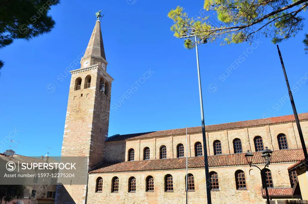 The ancient roman basilica of Saint Euphemia in Grado Italy. The clock tower is surmounted by the archangel Michael