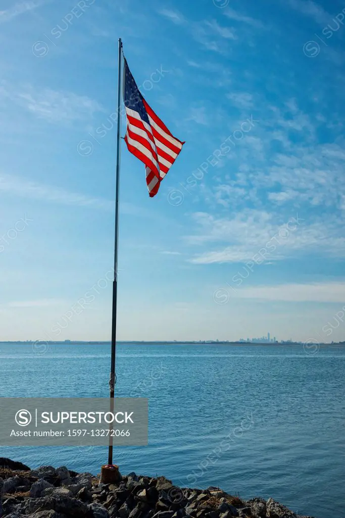 USA, New York, Queens, Jamaica Bay, American flag at Jamaica Bay looking to New York City