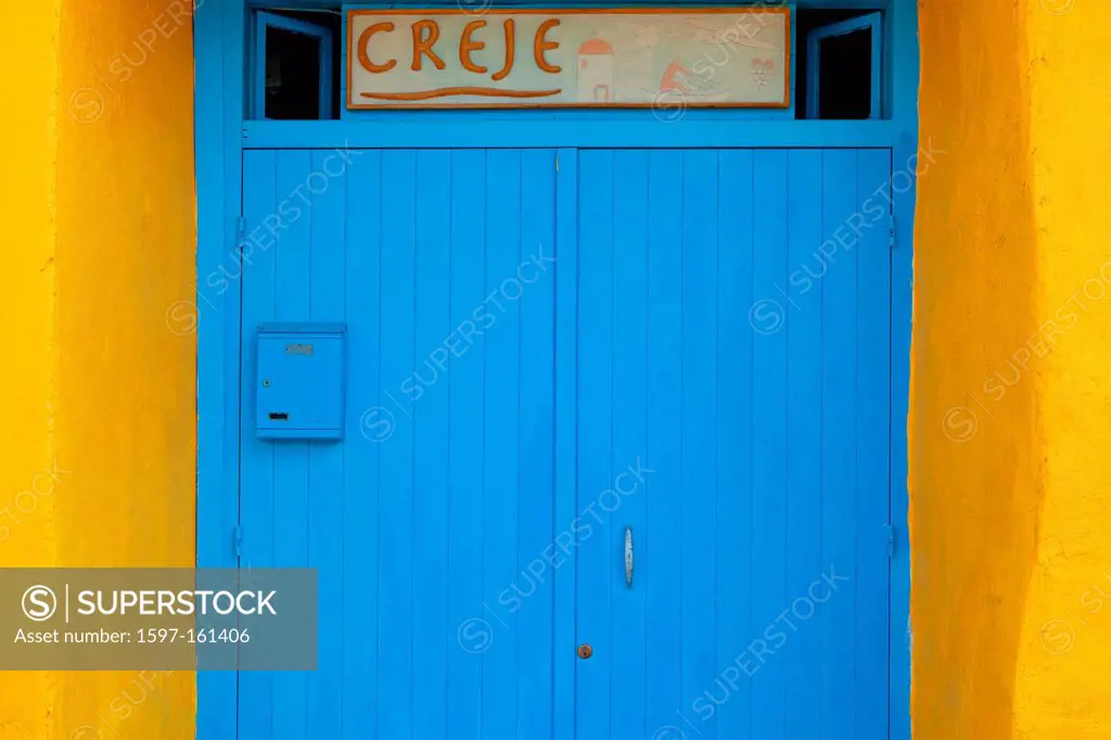 Italy, procida, Corricella _ architectual detail of yellow wall and blue door.
