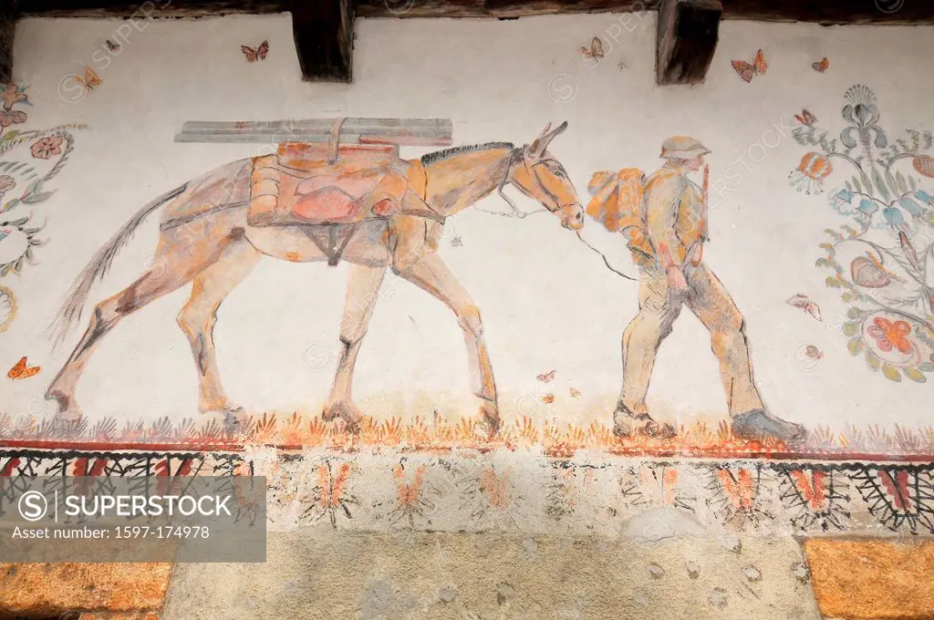 Fresco on an old wall of a soldier with rifle leading a mule