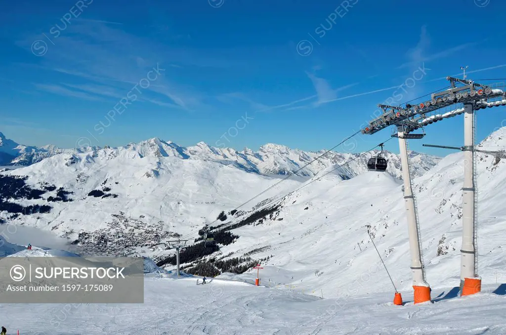 Skiing in the famous ski resort of Verbier in the Swiss Alps. In the background the bernese alps. In the foreground empty slopes with just a few skier...