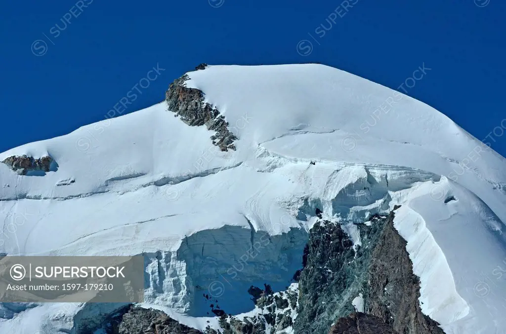 the summit and north face of the Allalinhorn in the southern swiss alps between Zermatt and Saas Fee. Showing a team of, on the summit