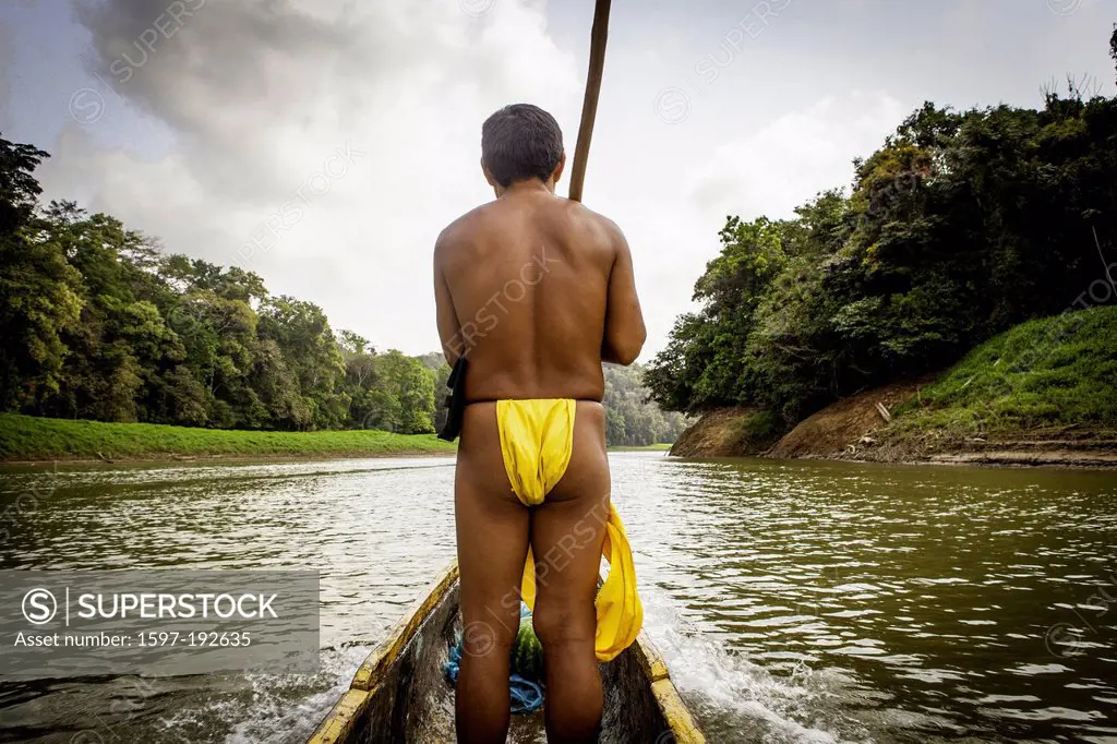 Embera Indian guiding dugout canoe up river just outside of Panama City, Panama Central America