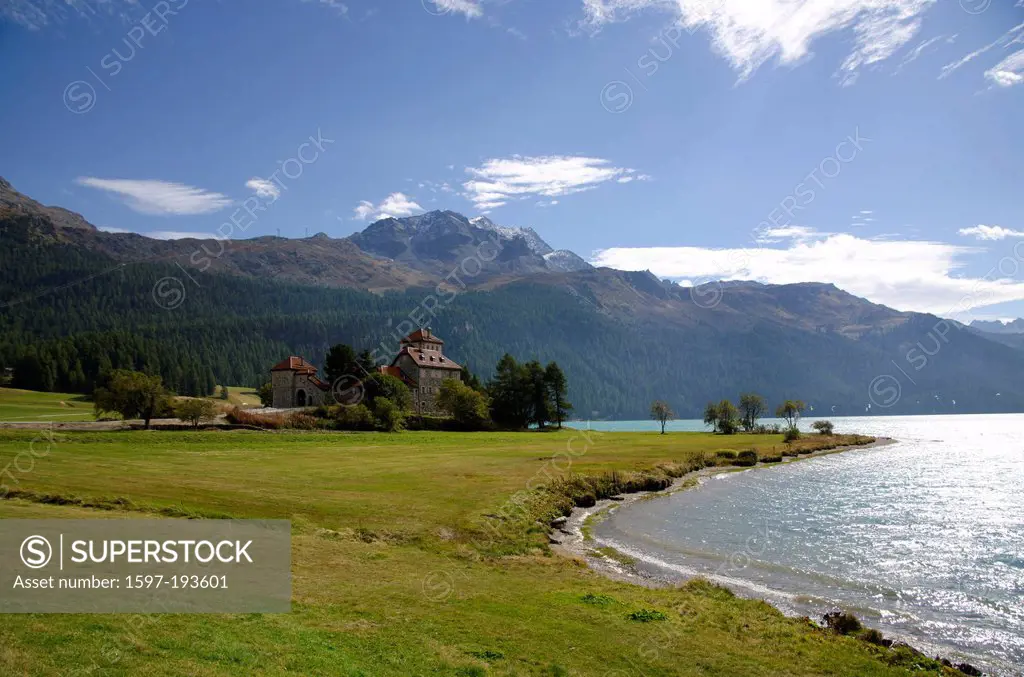 Castle crap da sass on the lake front with snow-capped mountain and lake silvaplana with blue sky and clouds in grisons Switzerland, Europe,
