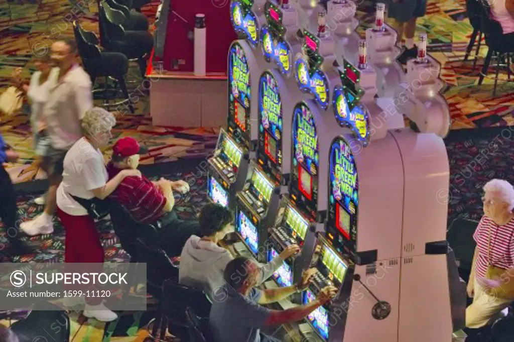 Rows of slot machines and gamblers at Rio Casino in Las Vegas, NV