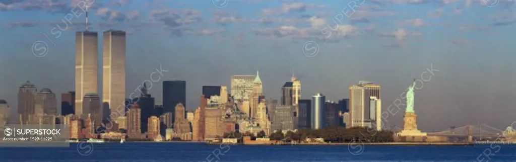 Panoramic sunset view of World Trade Towers, Statue of Liberty, Brooklyn Bridge, and Manhattan, NY skyline