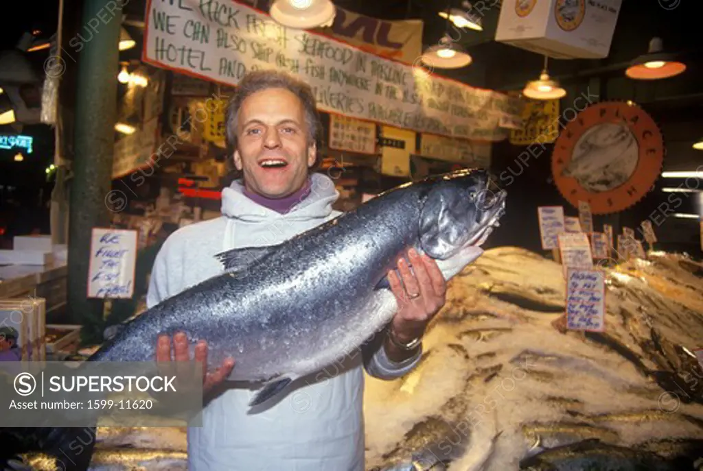 Fish seller at Salmon stand at Pike Place Public Farmers Market, Seattle, WA