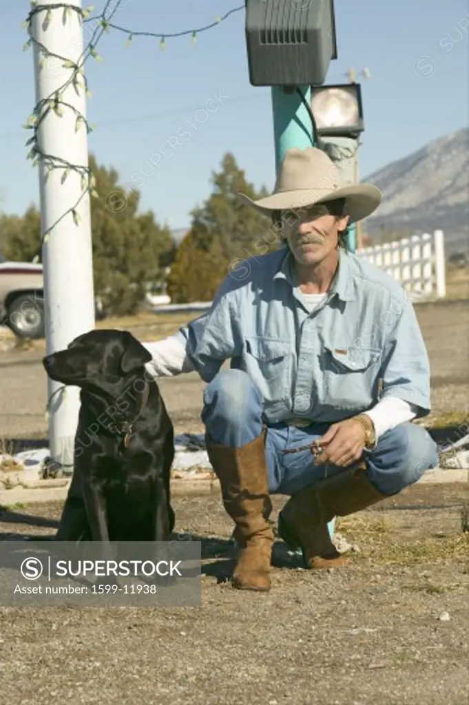 Cowboy with his dog kneel down at the Sands Motel at the intersection of Route 54 & 380 in Carrizozo, New Mexico