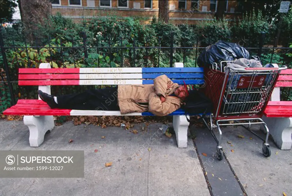 A homeless man sleeping on a park bench, Jersey City, New Jersey