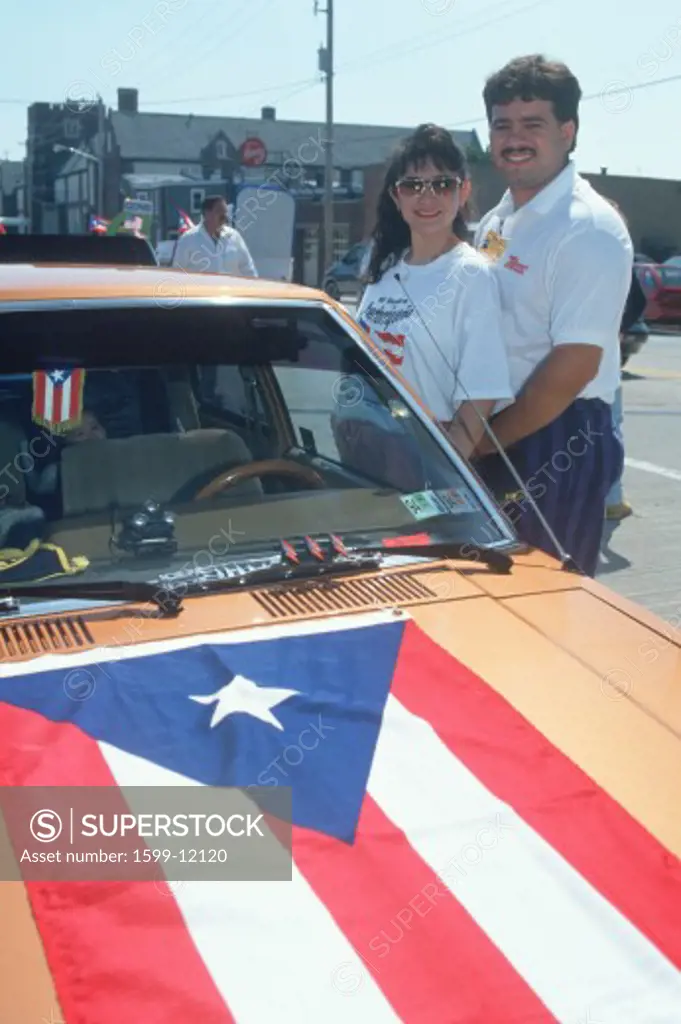 A Puerto Rican couple with their flag draped car, Wilmington, DE