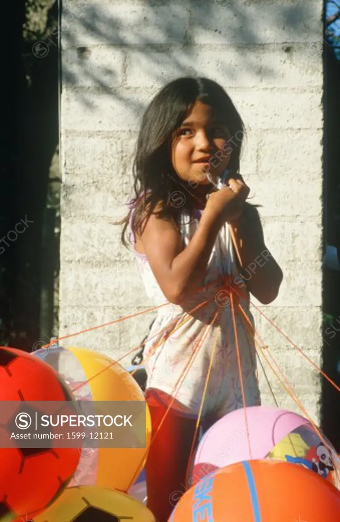 A Mexican girl holding balloons