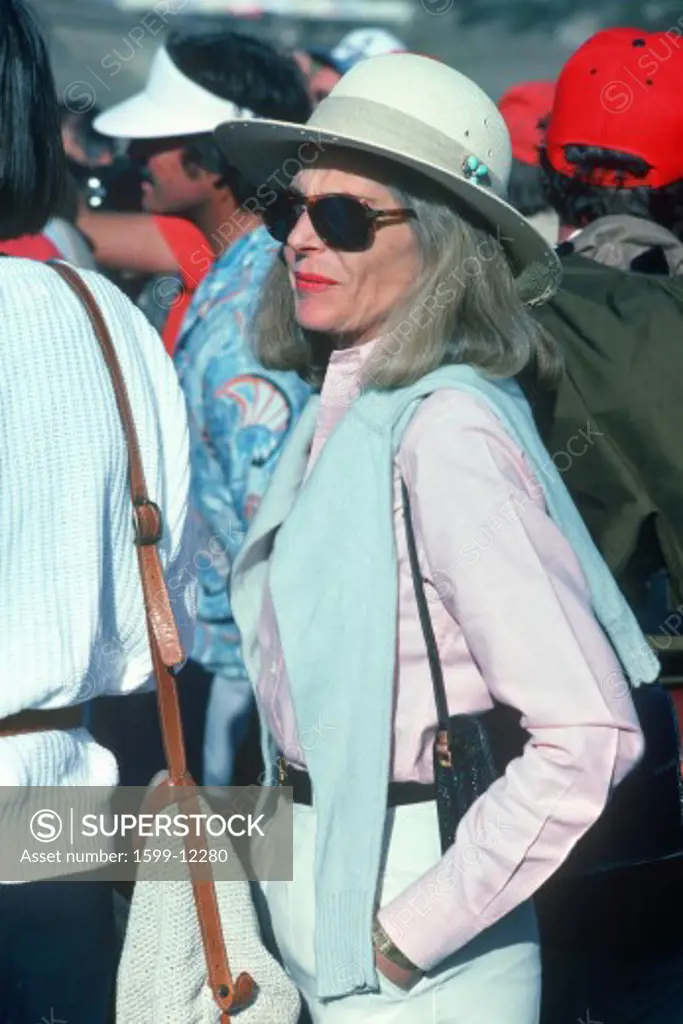 A middle aged woman in fedora and sunglasses