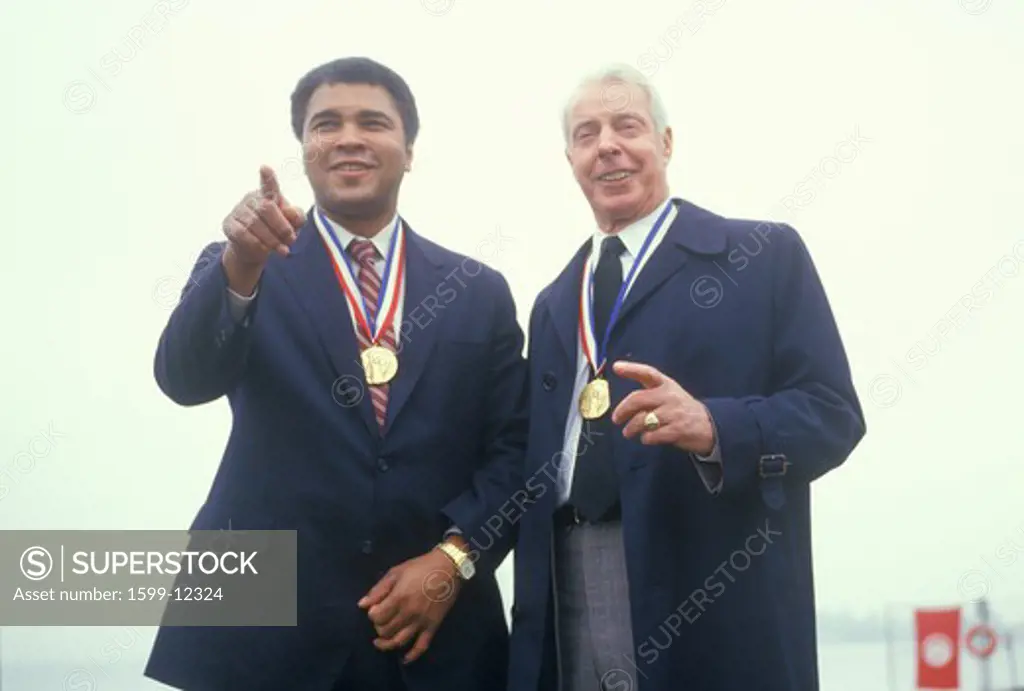 Muhammed Ali and Joe DiMaggio wearing gold medals, Ellis Island, NY 