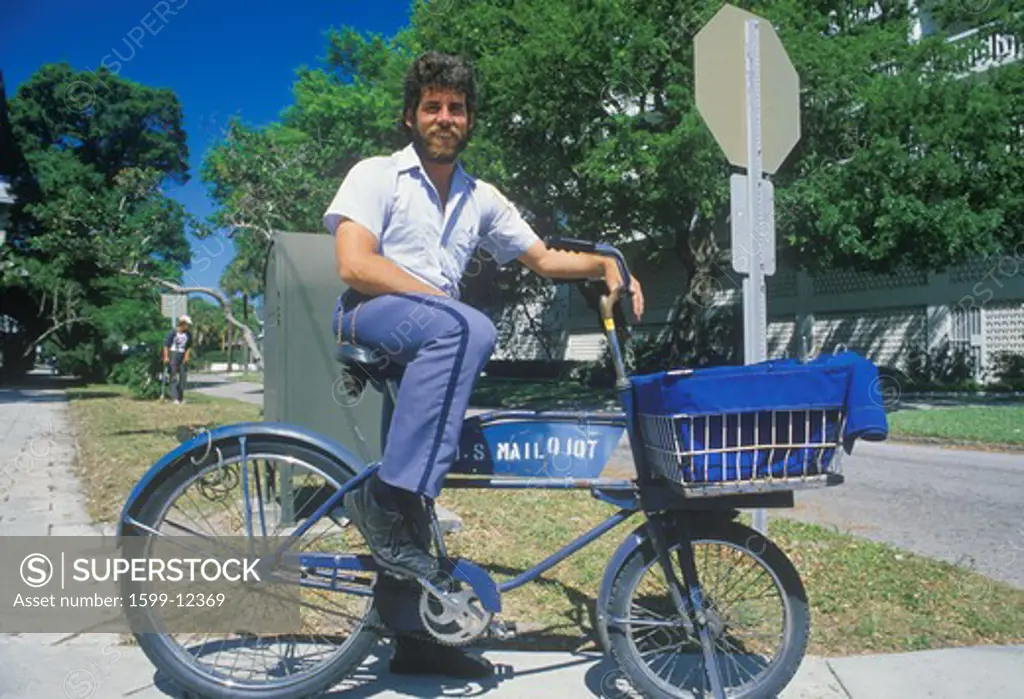 An Latino mail carrier bicycling on his route, St. Petersburg, FL