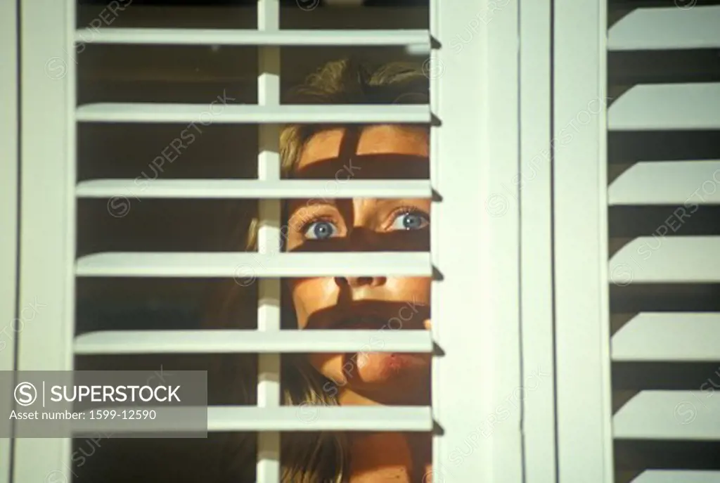 Scene with actress looking through blinds from set of 'Temptation', feature film, Miami, FL