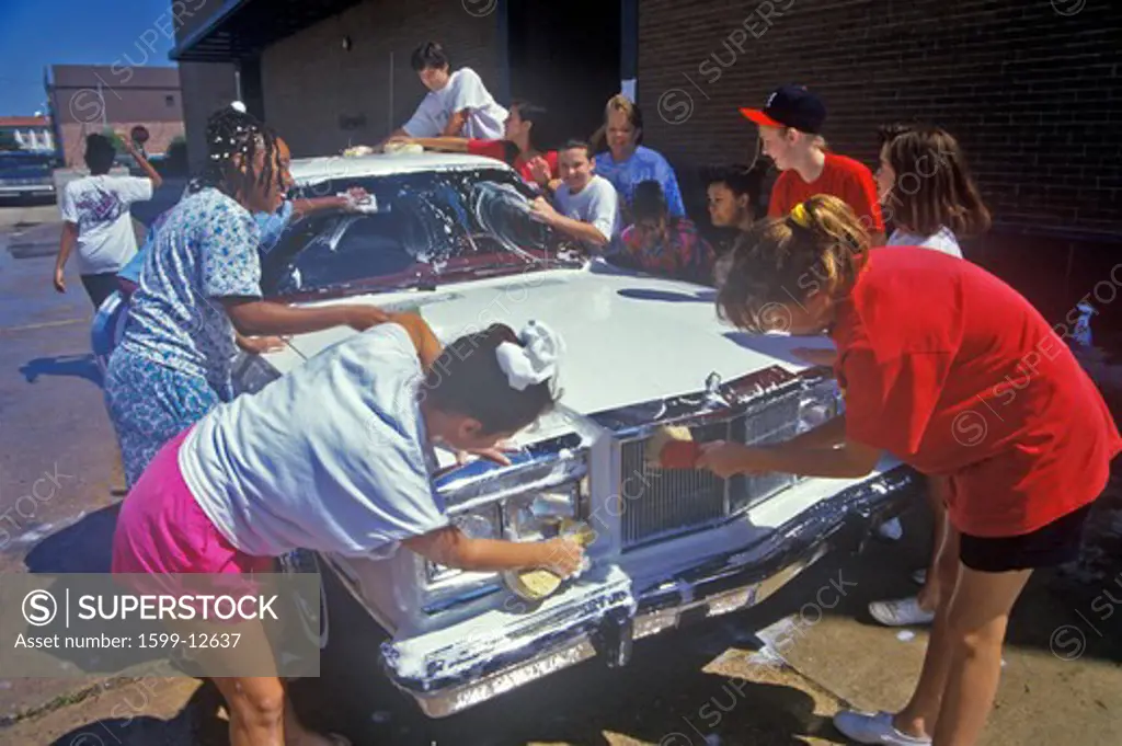 Young girls at a community car wash scrubbing an automobile, Hope, AR