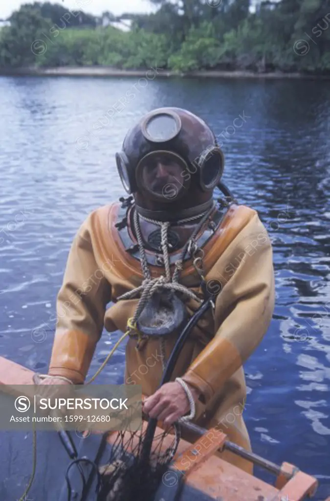 Historic Greek sponge diver in antique diving suit dives for sponges in Tarpon Springs FL