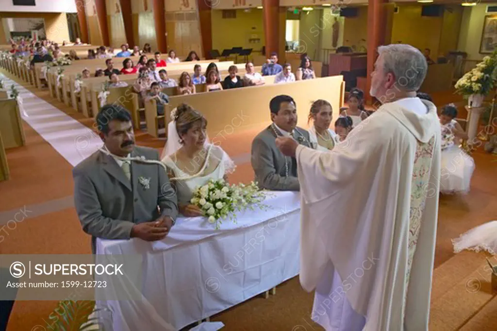 Catholic Priest administers wedding vows to two Latino-American couples at St. Thomas Catholic Church in Ojai, California