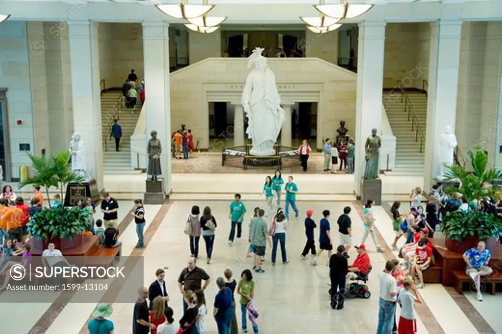 Elevated view of interior of U.S. Capitol Visitor Center with crowds walking around the Statue of Freedom, Washington, D.C.