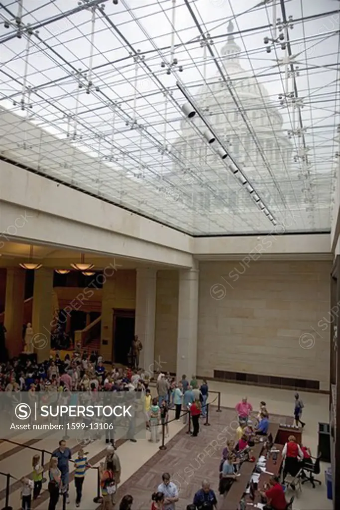 Tourists standing in line for tickets with view of U.S. Capitol through glass windows at the U.S. Capitol Visitors Center, Washington, D.C.