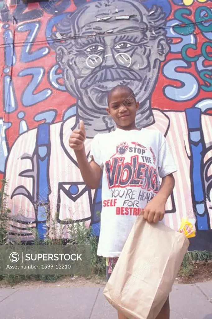 An African-American boy in front of a mural, Washington, D.C.