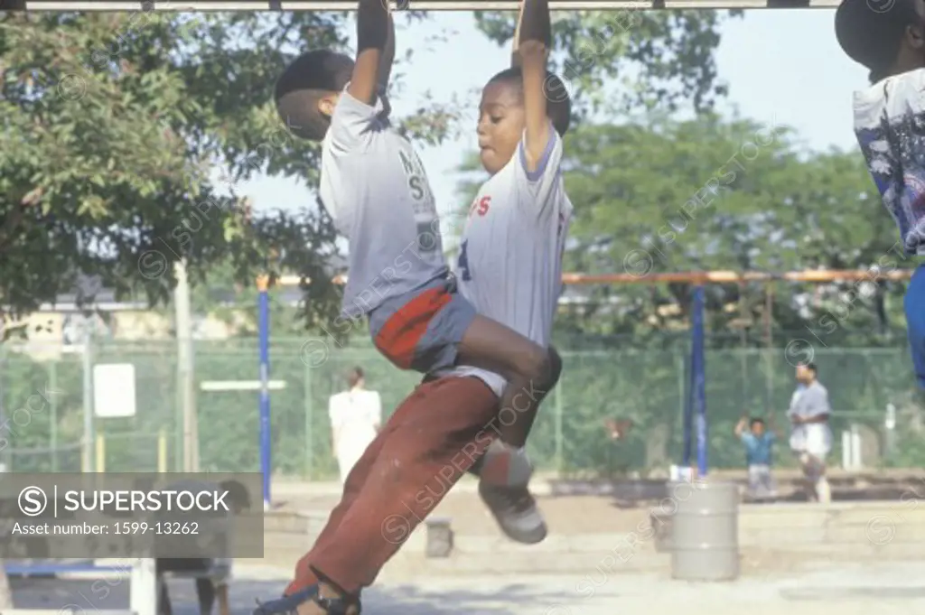 Two African-American children playing on playground equipment in Chicago, IL