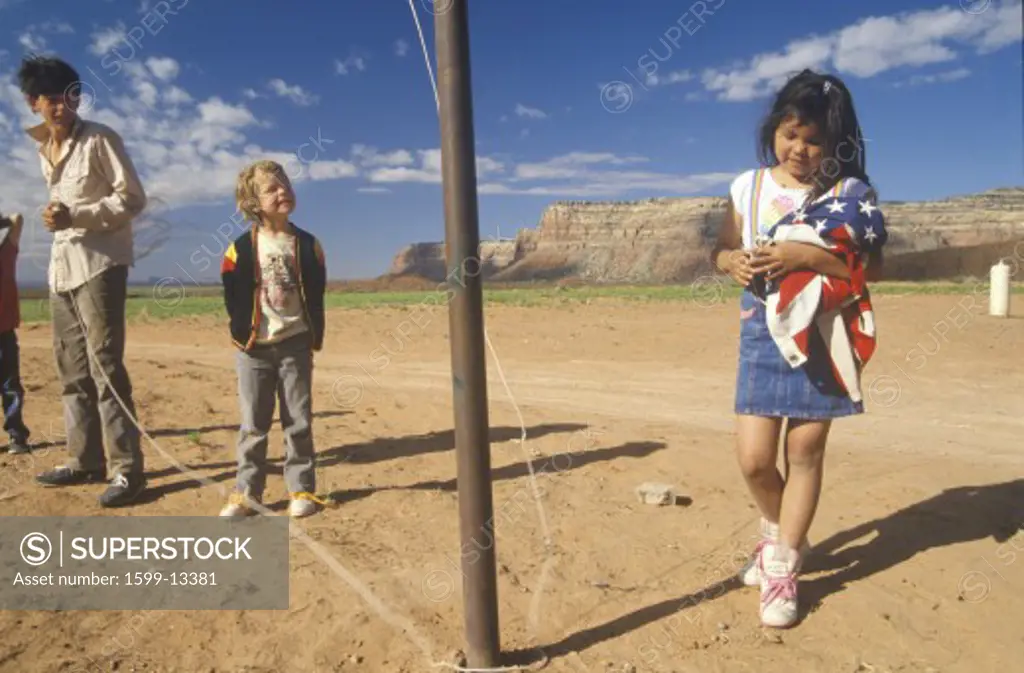 Caucasian boy looking at Navajo girl with American flag at Valley of Gods, Lee Ranch, UT