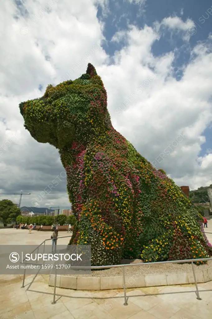 Jeff Koons' living plant sculptor of dog in front of the Guggenheim Museum of Contemporary Art of Bilbao (Bilbo), located on the North Coast of Spain in the Basque region. Nicknamed 'The Hole', this is a contemporary museum built of titanium, limestone and glass and was designed by Canadian citizen, Frank O. Gehry in 1997.