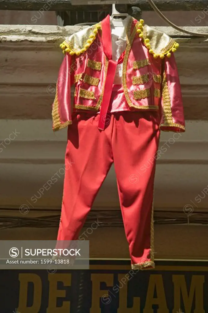 Red toreador bull fighting outfit for boy hangs in Centro old district of Sevilla Spain