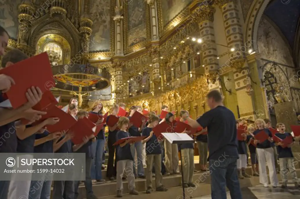 Boys & girls choir singing in the Benedictine Abbey at Montserrat, Santa Maria de Montserrat, near Barcelona, Catalonia, Spain with Black Madonna in background