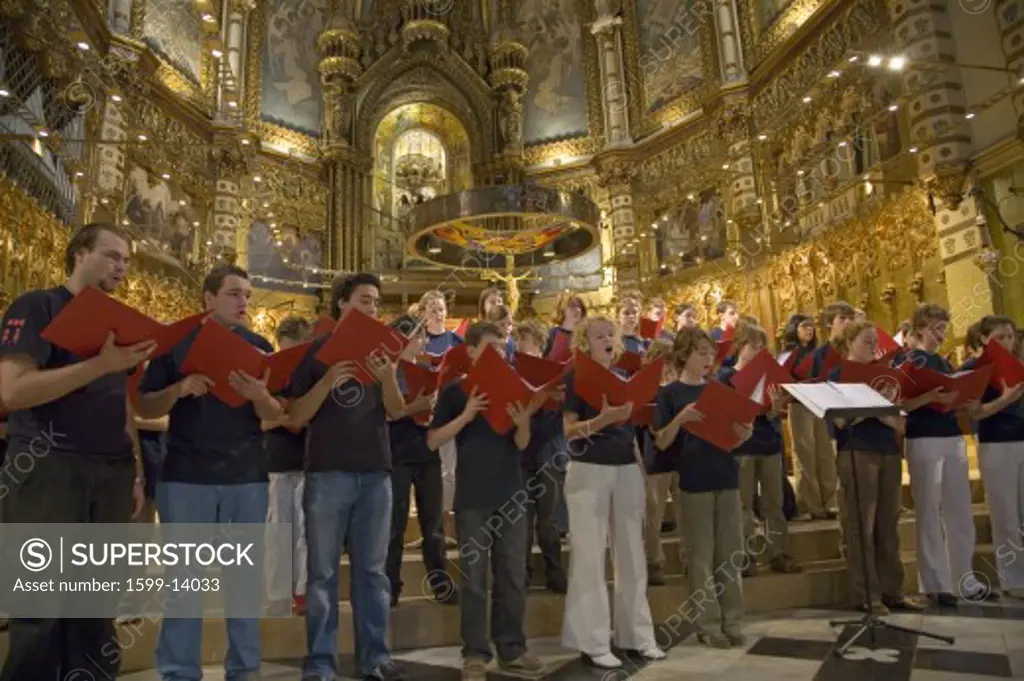 Boys & girls choir sing in the Benedictine Abbey at Montserrat, Santa Maria de Montserrat, near Barcelona, Catalonia, Spain with Black Madonna in background