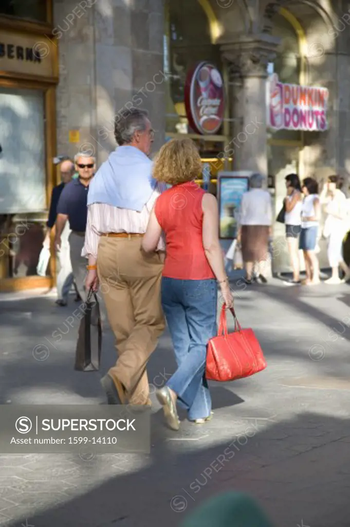 Couple shopping on Passeig de Gràcia in the Eixample district, busy street in Barcelona, Spain, Europe