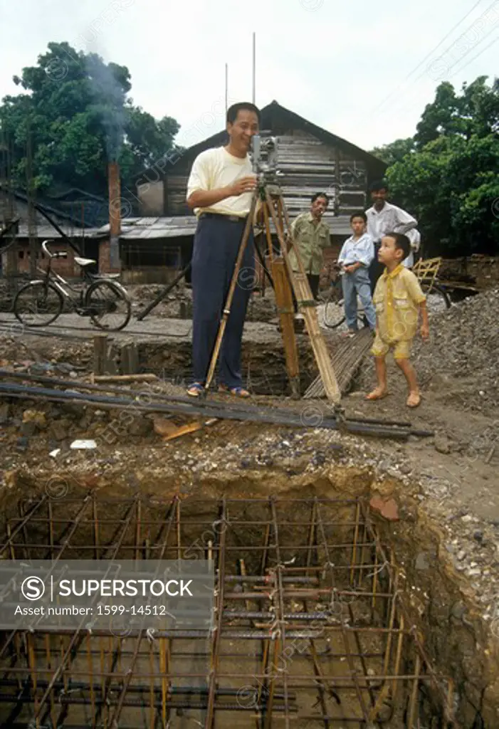 Building surveyor at land site for new construction in Guilin, Guangxi Province, People's Republic of China