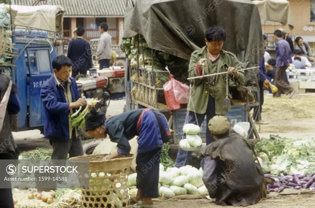 Selling vegetables at Yi Minority People's Marketplace near Dali, Yunnan Province, People's Republic of China
