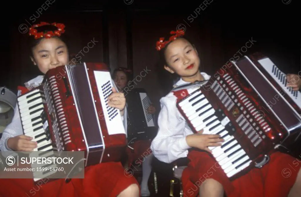 Child musician performing on Accordion at Jing Guang Hotel in Beijing in Hebei Province, People's Republic of China