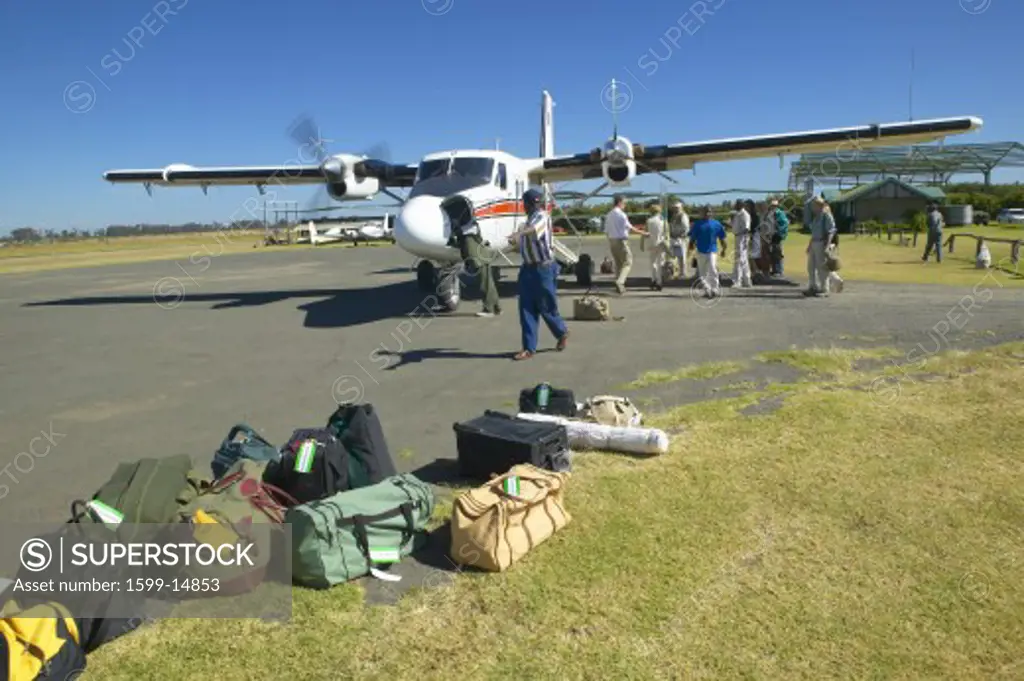 Airplane on landing strip headed to Masai Mara Kenya with luggage to be loaded