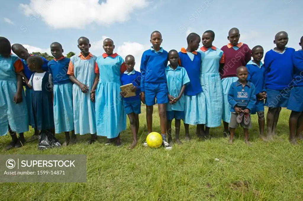 Children in blue uniforms holding soccer ball at school near Tsavo National Park, Kenya, Africa