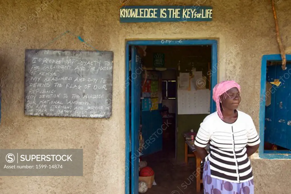 Knowledge is the key for life sign and teacher in front of school house near Tsavo National Park, Kenya, Africa