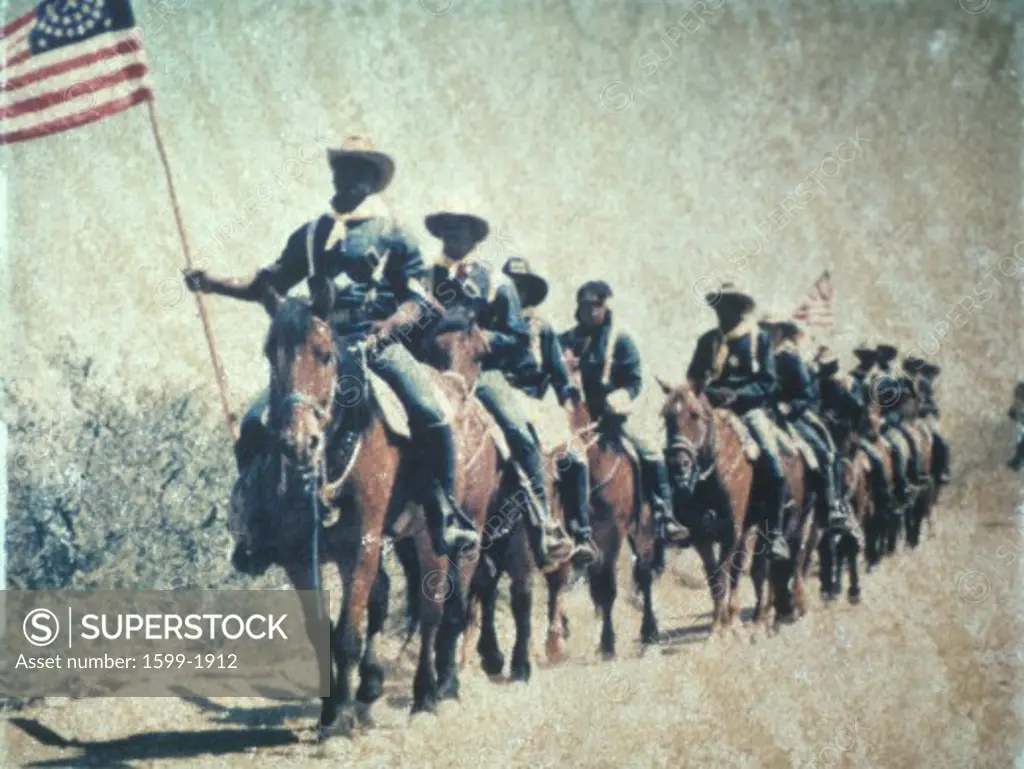 Historical reenactment of U.S. cavalry on horseback with American flag