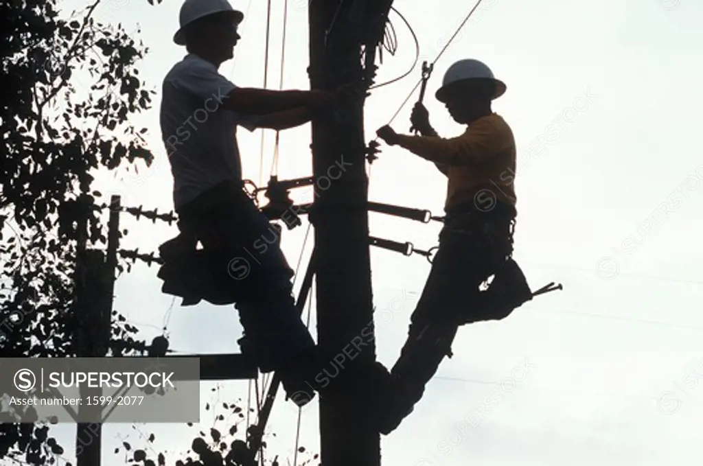 Two telephone repairmen working on pole in Ojai, California