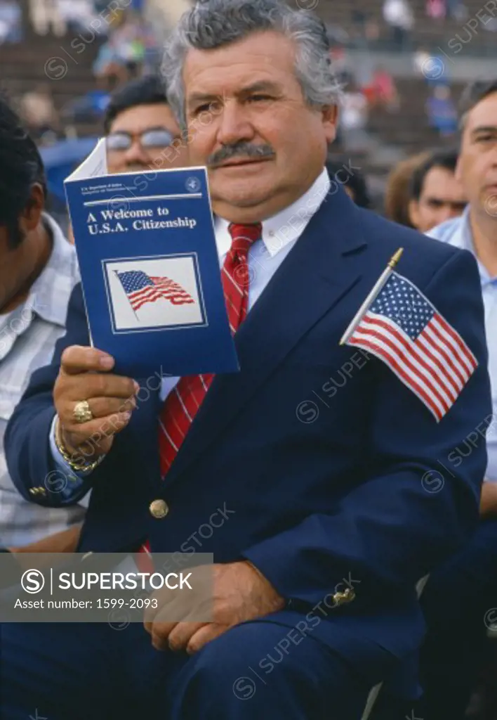 Latino American man with U.S. citizenship book at induction ceremony in East Los Angeles, CA 