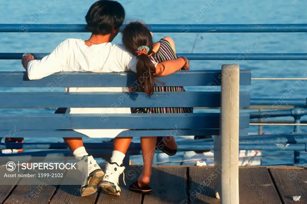 Asian couple on bench at Santa Monica Pier, California