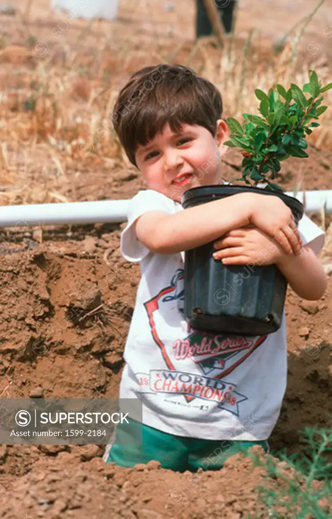 Latino boy planting a seedling on Earth Day, Los Angeles, California