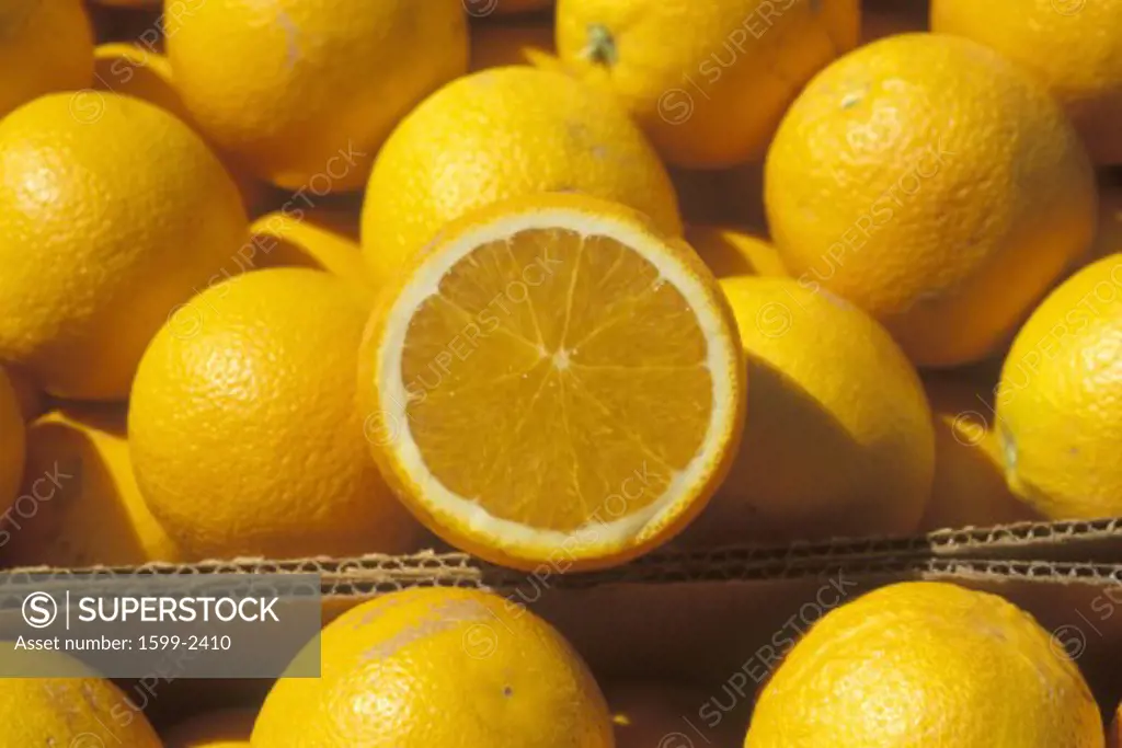 A halved orange rests on oranges in boxes in Ventura County ,CA