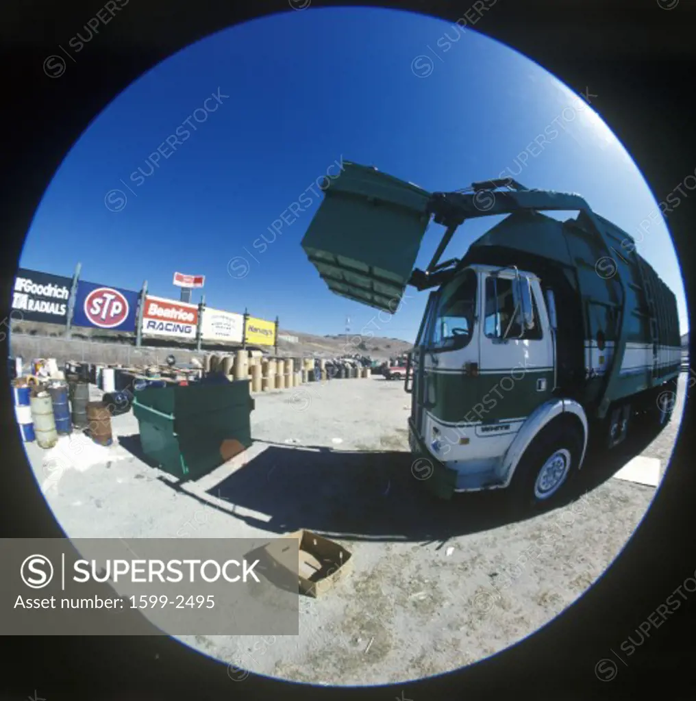 A trash truck unloading a garbage container